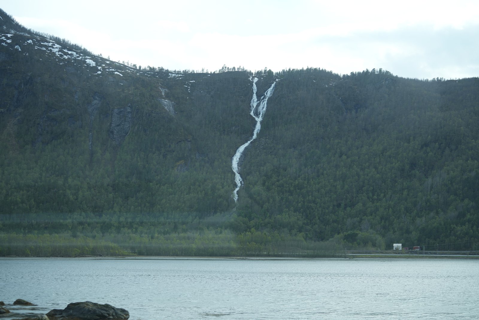 Ein Wasserfall stürzt in den Fjord